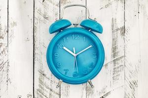 homemade turquoise alarm clock on white wooden background photo