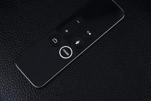 Modern Remote control TV or radio on dark leather background.Top view, minimalism photo