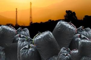 bolsa negra de basura aislada en el fondo del paisaje de la industria, bolsa de basura foto