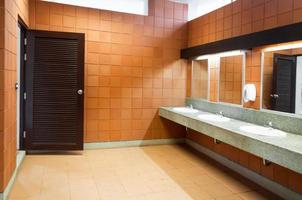 Interior of public clean toilet in a shared toilet there is a wide selection of sinks with mirrors photo