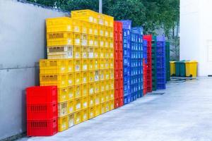 caja de plástico de colores. Contenedores de embalaje de frutas apiladas en el supermercado foto