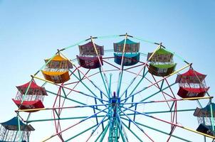 jugador de rueda de ferris de los niños divertidos con cielo azul, rueda de ferris antigua y vintage foto