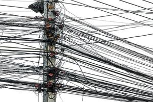 caos desordenado de cables con cables en poste eléctrico sobre fondo blanco, los muchos cables eléctricos en los postes de energía foto