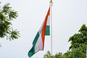 India flag flying high at Connaught Place with pride in blue sky, India flag fluttering, Indian Flag on Independence Day and Republic Day of India, tilt up shot, Waving Indian flag, Har Ghar Tiranga photo