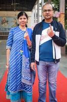 New Delhi, India - December 04 2022 - Unidentified people showing their ink-marked fingers after casting votes in front of polling booth of east Delhi area for MCD local body Elections 2022 photo