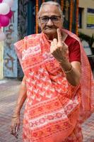 New Delhi, India - December 04 2022 - Unidentified people showing their ink-marked fingers after casting votes in front of polling booth of east Delhi area for MCD local body Elections 2022 photo