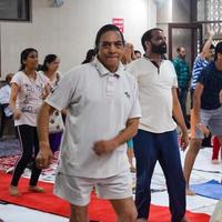 Delhi, India, June 19 2022 -Group Yoga Aerobics session for people of different age groups in Balaji Temple, Vivek Vihar, International Yoga Day, Big group of adults attending aerobics class in temple photo