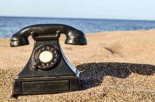 Old telephone at the beach photo