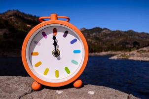 Analog clock on the rock photo