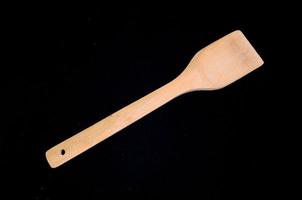 Wooden spoon on black background photo