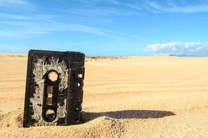 Old cassette tape in the sand photo