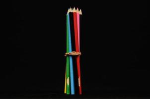 Colourful pencils on black background photo