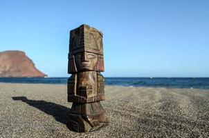 pequeña estatua de madera en la playa foto