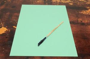 Paintbrush on a green paper photo