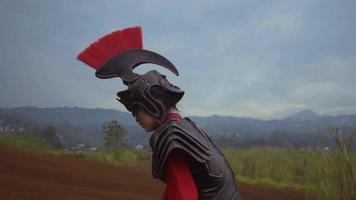 Eine Chinesin im Kriegskostüm, die verzweifelt auf dem Berg mit brauner Erde im Hintergrund spazieren geht video