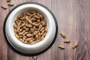 A bowl of dog food on a wooden floor. photo