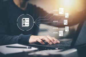 mano usando una computadora portátil y una carpeta táctil del sistema de gestión de documentos, base de datos de documentación en línea y automatización de procesos para administrar de manera eficiente los archivos, el trabajo, el conocimiento, la tecnología comercial corporativa, foto