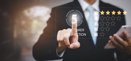 Businessman hold smartphone with Customer review satisfaction feedback survey concept, User give rating to service experience on online application, service leading to reputation ranking of business. photo