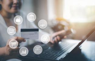 Woman holding credit card for makes a purchase on the Internet on the laptop computer with credit card, online payment, shopping online, e-commerce, internet banking, spending money concept. photo