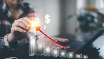 Businesswoman write growth graph losses on the stock market chart concept, Business use pen touch line market chart and Red arrows fall to the ground, indicating the economic recession. photo