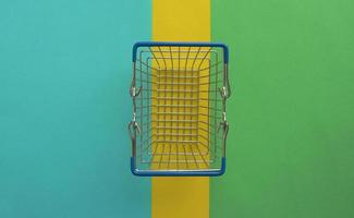 Empty shopping basket on colorful background. Shop trolley at supermarket. Sale, discount, shopaholism, black friday, economy concept. Consumer society trend. Online Shopping Concept. photo