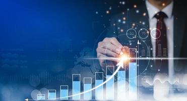 Businessman using pen touch bar graph of analytics and financial, Changes in new planning, Business growth, ideas and perspectives, Stock investment, and dividends yield from business in the new year photo