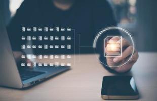 Businessman working on laptop and touch screen Online documentation database, IT consultant being set up Virtual Document Management System with laptop,Software for archiving corporate files. photo