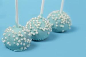 Candies on sticks. Blue cakes on a blue background.Beautiful sweet dessert photo