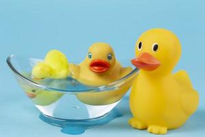 A yellow rubber duck floats in a bathtub on a blue background. photo