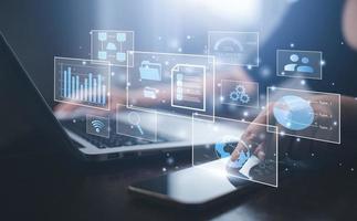 Businessman working on laptop and touch screen Online documentation database, IT consultant being set up Virtual Document Management System with laptop,Software for archiving corporate files. photo