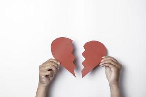 Close up of paper broken heart isolated on white background photo