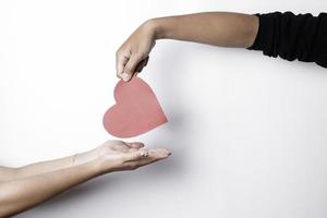 una foto de un papel en forma de corazón rojo aislado sobre fondo blanco.