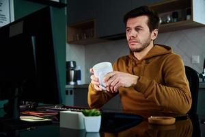 Tired man works late at workplace, use computer photo