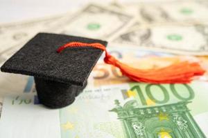 Graduation gap hat on US dollar banknotes money, Education study fee learning teach concept. photo