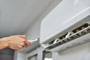 Hand adjusting temperature on air conditioner photo