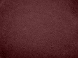 textura de tela de terciopelo rojo oscuro de color baya de invierno utilizada como fondo. fondo de tela roja de material textil suave y liso. hay espacio para el texto. foto