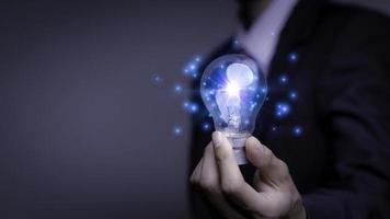 Businessman holding a light bulb, Creative new idea. Innovation, brainstorming, solution and inspiration concepts. imagination, creative thinking problem solving. photo