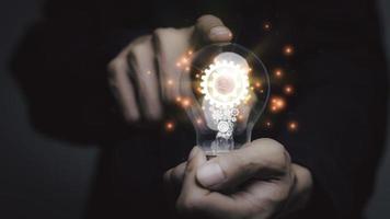 Businessman holding a light bulb, Creative new idea. Innovation, brainstorming, solution and inspiration concepts. imagination, creative thinking problem solving... photo