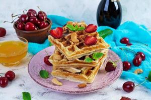 Delicious breakfast with belgian waffles. Waffels with strawberry and berry jam photo