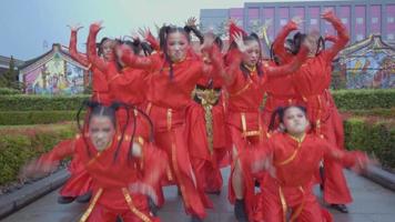 A Group of Asian teenagers dancing a hip-hop dance in red Chinese dress inside the temple video