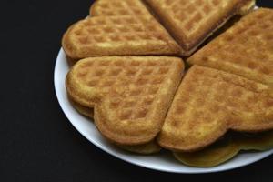 Heart-shaped waffles on a white plate. Delicious heart-shaped waffles. photo