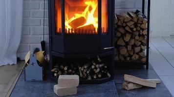 Fuel briquettes made of pressed sawdust for kindling the furnace - economical alternative eco-friendly fuel for the fireplace in the house. Firewood is burning in the oven in the interior video