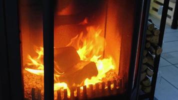 Fuel briquettes made of pressed sawdust for kindling the furnace - economical alternative eco-friendly fuel for the fireplace in the house. Firewood is burning in the oven in the interior video