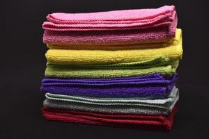 Multicolored rags in a pile. A bunch of colored towels. Terry towels. A cleaning cloth. photo