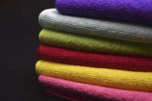 Multicolored rags in a pile. A bunch of colored towels. Terry towels. A cleaning cloth. photo