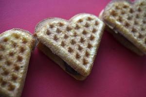 Waffle hearts on a red background. Valentine's day. Confectionery products in the form of a heart. photo