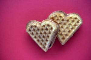 Waffle hearts on a red background. Valentine's day. Confectionery products in the form of a heart. photo