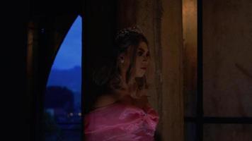 A Princess with a pink dress walking slowly in the dark while wearing a crown and tiara video