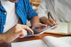 College students are studying and reading together. Have a touch tablet computer for information. photo