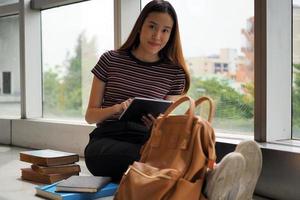 Asian girl students use the tablet to study and find information in the library. photo